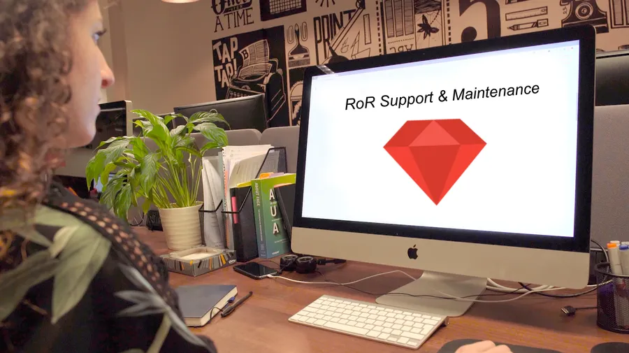 Woman at computer conducting support and maintenance of an RoR application